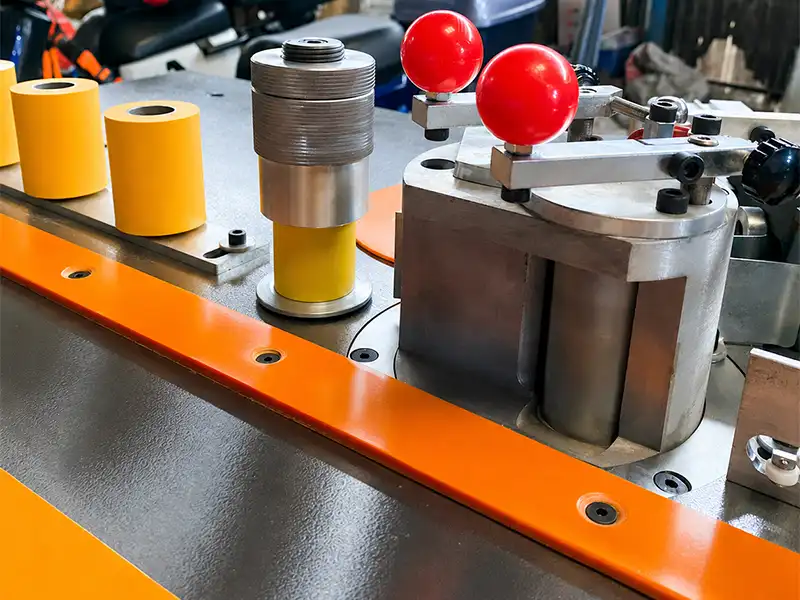 Ergonomic multi-roller panel guidance and heavy-duty manual pressure station on the HE-305 edge bander for stable workpiece feeding.