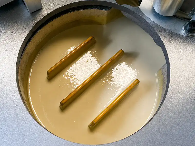 Internal view of the HE-305 manual edge bander high-capacity melting pot showing the non-stick coating and internal multi-heating ribs for rapid adhesive melting.