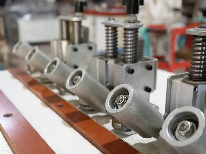 Detailed view of the HE-305B bevel guide wheel mechanism showing the adjustable multi-angle scale and spring-loaded suspension shock absorbers.