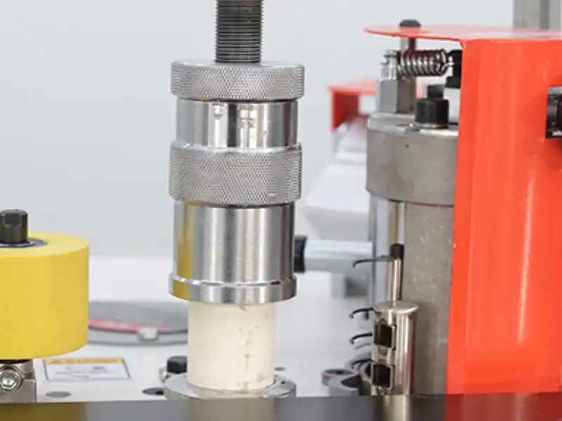Detailed view of the HE-305U heavy duty manual edge bander showing the mechanical height adjustment knob and vertical column mechanism on the main laminating pressure roller.