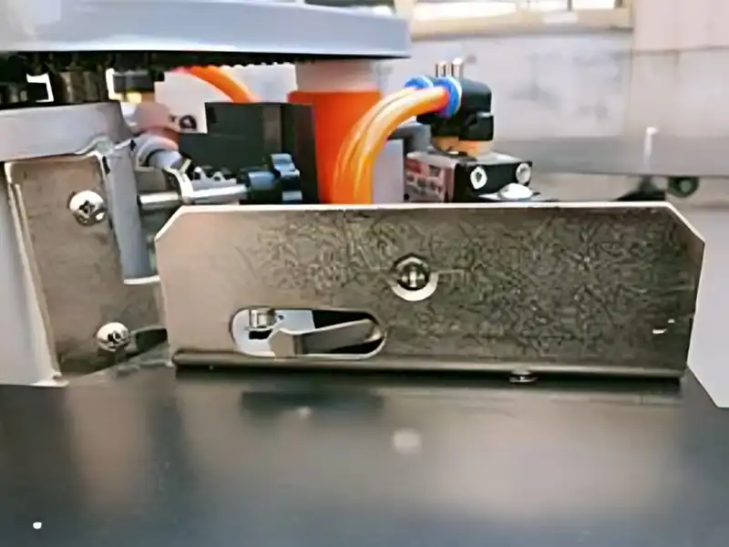 Detailed view of the high-sensitivity mechanical belt-feeding travel switch on the HE-305U manual edge bander, regulating tape cutting synchronization.